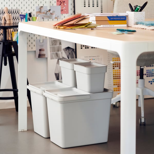 Un espace de travail moderne avec un système de poubelle de tri des déchets HÅLLBAR blanc. Les bacs sont empilables, en plastique recyclé et conçus pour l’organisation.