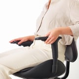 Personne ajustant l’accoudoir de la chaise de bureau. La chaise HATTEFJÄLL est dotée d’accoudoirs réglables en 2D, une caractéristique ergonomique clé pour le confort et le soutien de la posture.