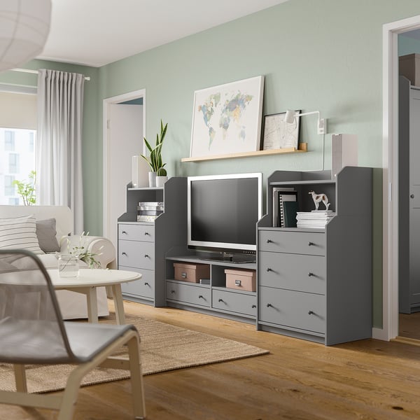 Salon moderne avec séquence HAUGA : meubles de rangement gris, télévision à écran plat, décoration carte du monde, parquet et murs végétaux.