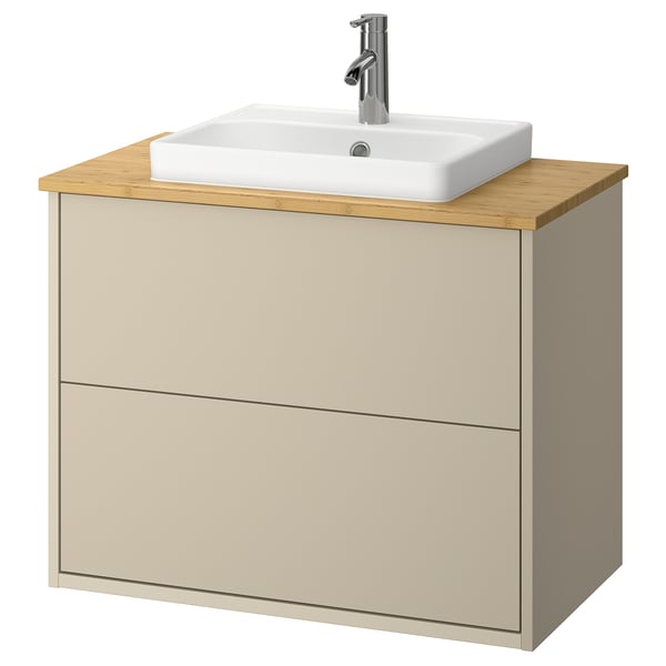 Armoire de salle de bain beige avec comptoir en bambou, lavabo blanc et robinet argenté.