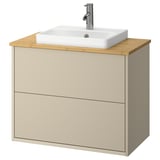 Armoire de salle de bain beige avec comptoir en bambou, lavabo blanc et robinet argenté.