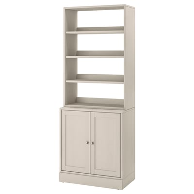 Un meuble de rangement HAVSTA beige clair. Il ouvre les étagères sur le dessus et ferme les armoires en dessous avec un design en bois.