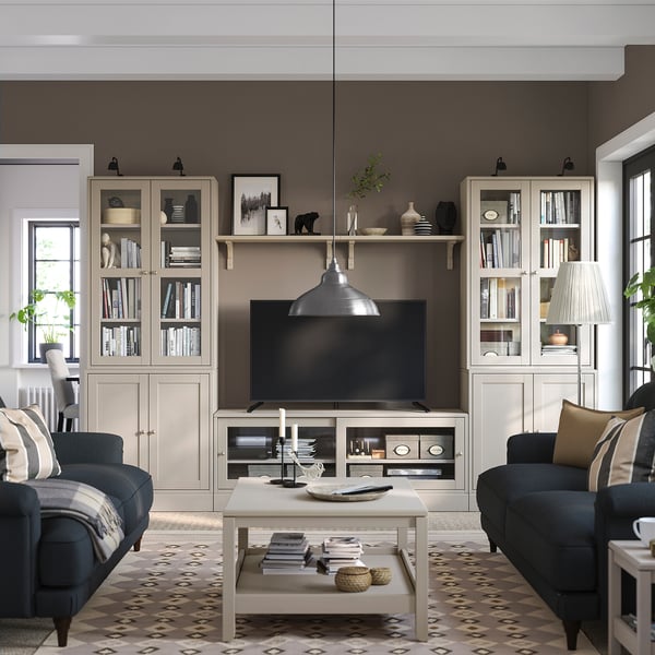 Salon gris avec canapés, tapis, meuble tv, décor, lampe, fenêtre, ambiance chaleureuse.