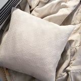 Oreiller en coton blanc cassé avec motif texturé, forme rectangulaire, fermeture à glissière.