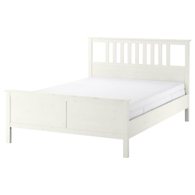 Un lit HEMNES blanc avec un cadre en pin massif, doté d’une tête et d’un pied de lit hauts. Il comprend un sommier réglable et un matelas en mousse.