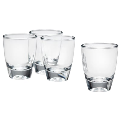 Quatre petits verres clairs en verre, disposés en forme de triangle avec un sur le côté, parfaits pour servir des boissons fortes.