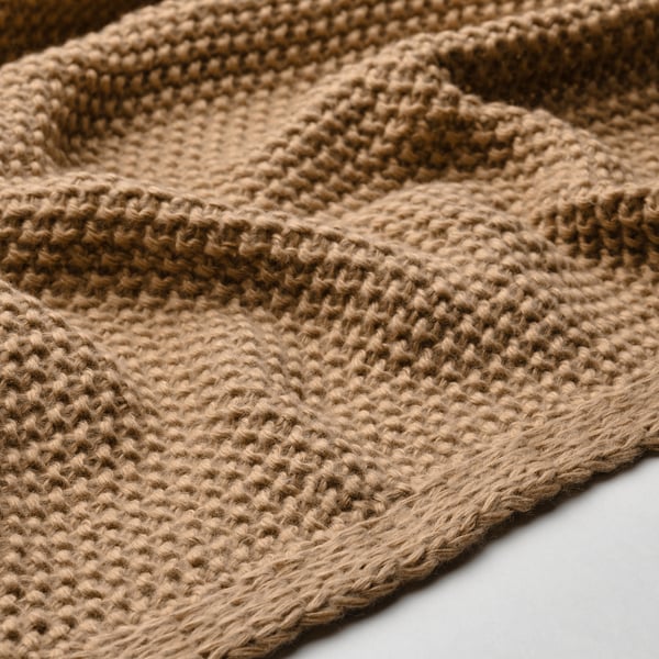 Texture de couverture douce tricotée à la main en fil recyclé brun clair.