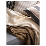 Plaid jaune-beige sur canapé, écologique et doux.