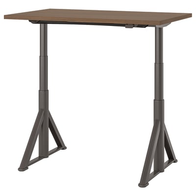 Bureau réglable IDÅSEN, plateau marron foncé, pieds en métal noir, base triangulaire, réglable en hauteur.