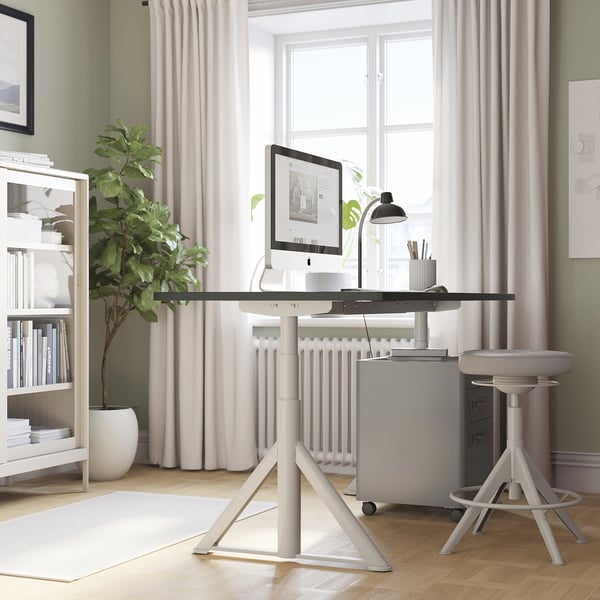 Bureau ajustable ikea IDÅSEN dans le bureau à domicile, blanc, grand, près de la fenêtre.