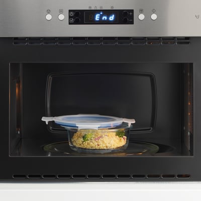Un récipient alimentaire en verre avec un couvercle étanche à l’intérieur d’un micro-ondes, prêt à réchauffer les restes.