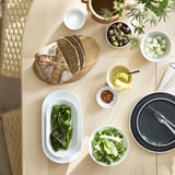 Table minimaliste avec salade, pain, fromage et ustensiles.
