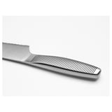 Couteau dentelé en acier inoxydable avec manche rainuré pour une prise en main sûre, posé sur une surface plane.