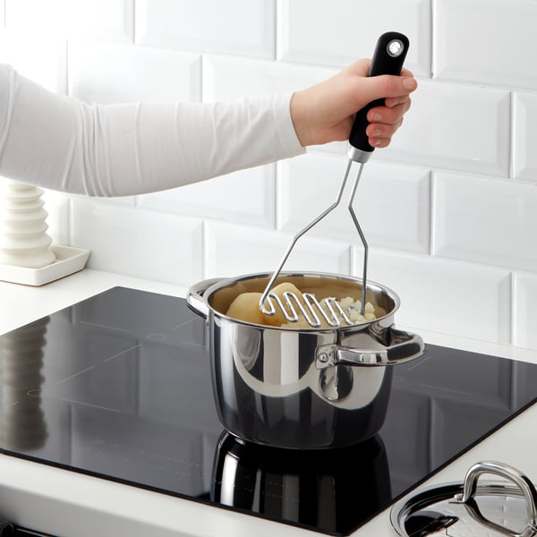 La personne utilise un presse-purée IKEA sur une cuisinière. La poignée du presse-purée a une prise ferme et une encoche pour éviter de glisser.