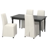 Table à manger rectangulaire noire moderne avec quatre chaises rembourrées de couleur crème.