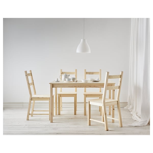 Ensemble de salle à manger simple en bois clair, comprenant une table et quatre chaises. Design minimal avec des éléments en bois de couleur claire.