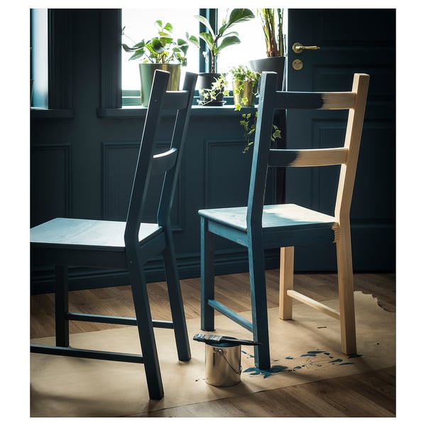 Deux chaises en bois sous fenêtre avec des plantes. Une lumière et une obscurité.