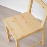 Chaise en bois naturel au design simple et à la finition légère, montrant des motifs de grain.