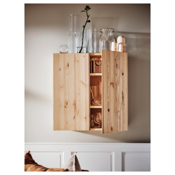 Armoire murale en bois avec vases en verre. Finition naturelle, design simple avec étagères ouvertes à l’intérieur.