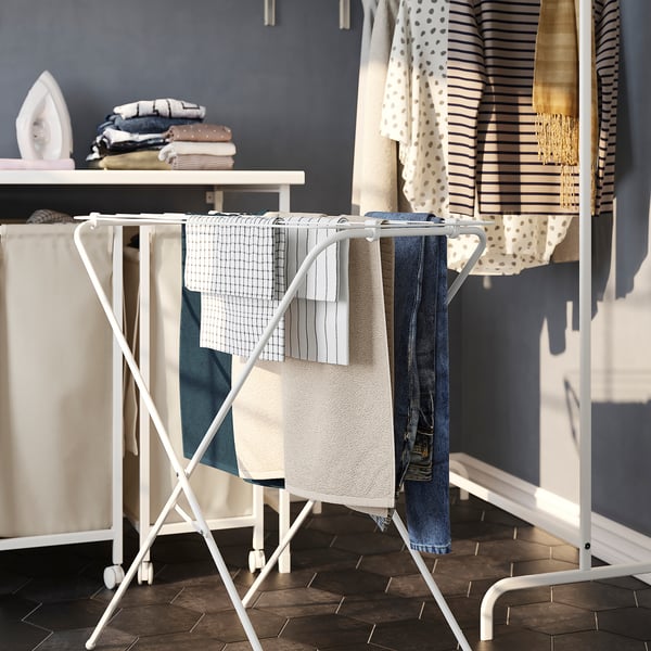 Séchoir pliable contenant des vêtements, faisant partie de la configuration de la lessive.