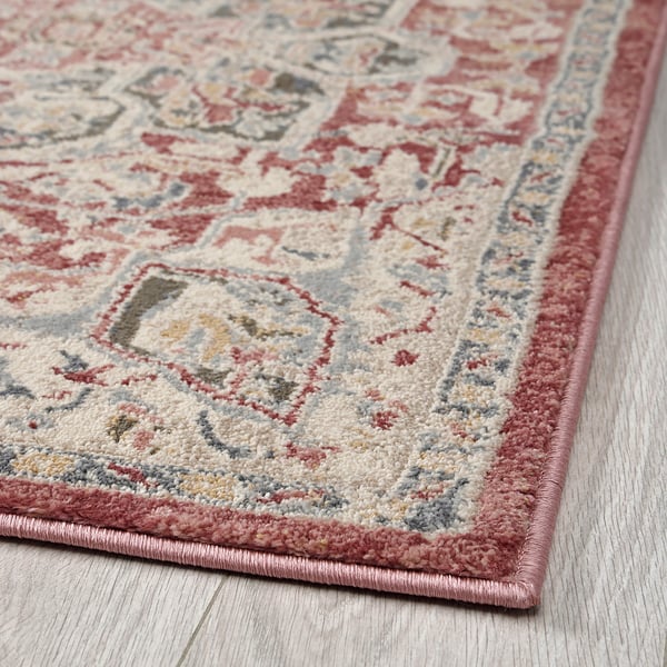 Tapis lumineux et orné de motifs floraux complexes dans des pastels doux. Matériau durable de haute qualité, idéal pour les zones à fort trafic.