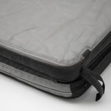 Coussins de chaise de patio noirs empilés avec housses en maille, mettant en valeur une construction robuste et un matériau de qualité.