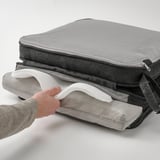Housse de coussin de chaise ouverte tenant la main, révélant une incrustation douce et rembourrée pour le confort et des points antidérapants pour la stabilité.