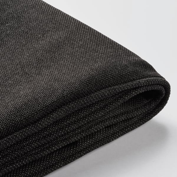 Housse de coussin noire avec un tissu lisse et tissé serré, montrant une texture de qualité et une durabilité.