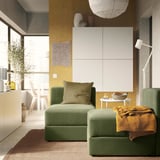 Salon moderne avec canapé JÄTTEBO texturé vert, coussin moelleux, décor en bois et mur jaune.