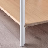Vous regardez une table moderne avec des bords élégants et un plateau en bambou lisse, soutenu par des pieds en métal robustes.