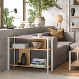 Salon minimaliste avec étagère en bambou JÄTTESTA, canapé gris et grande fenêtre.