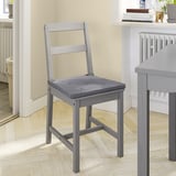 Une chaise en bois gris JUSTINA avec une assise rembourrée.