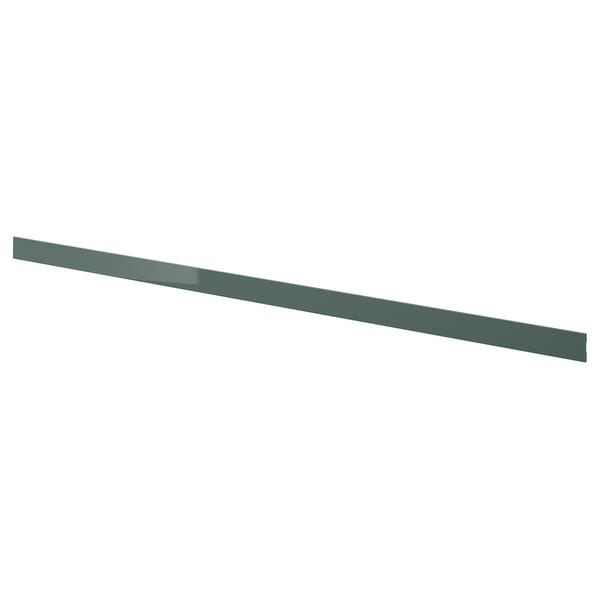 Le socle KALLARP en gris-vert brillant, avec une feuille de plastique, s’adapte parfaitement sous les armoires de cuisine pour une finition élégante.
