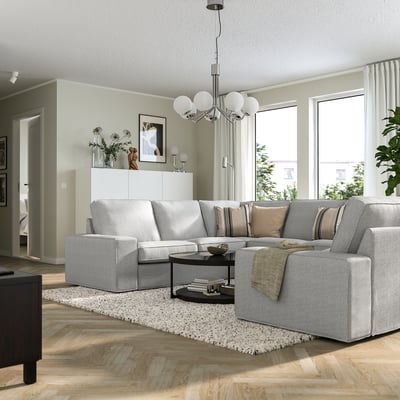 Salon moderne avec sectionnel KIVIK, tapis, table basse et lustre.