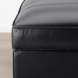 Gros plan du repose-pieds KIVIK en cuir noir, montrant un grain lisse et de haute qualité et des coutures soignées.