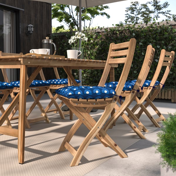 Chaises d’extérieur recyclées avec coussins à motifs bleus et plantes.