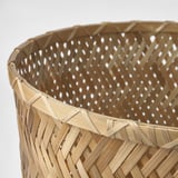 Gros plan d’un panier en bambou tressé, mettant en valeur des détails artisanaux complexes et un motif fin et entrelacé.