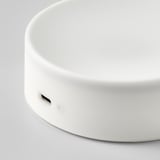 Lampe ronde, blanche et moderne avec surface lisse et port de charge usb-c.