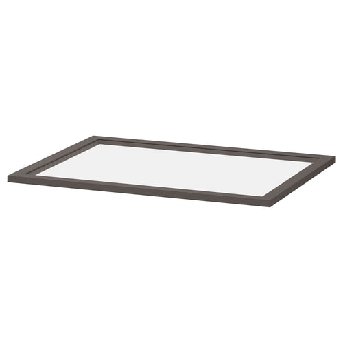 Une étagère en verre KOMPLEMENT gris foncé avec un cadre en carton et du verre trempé, conçue pour être facilement consultée et rangée dans une armoire.
