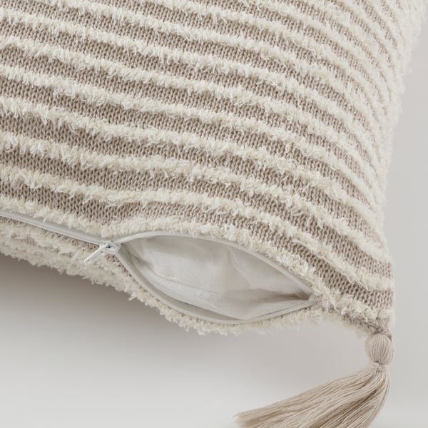 Coussin texturé épais avec rayures et franges. Fermeture éclair cachée pour un retrait facile de la housse.