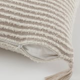 Coussin texturé épais avec rayures et franges. Fermeture éclair cachée pour un retrait facile de la housse.