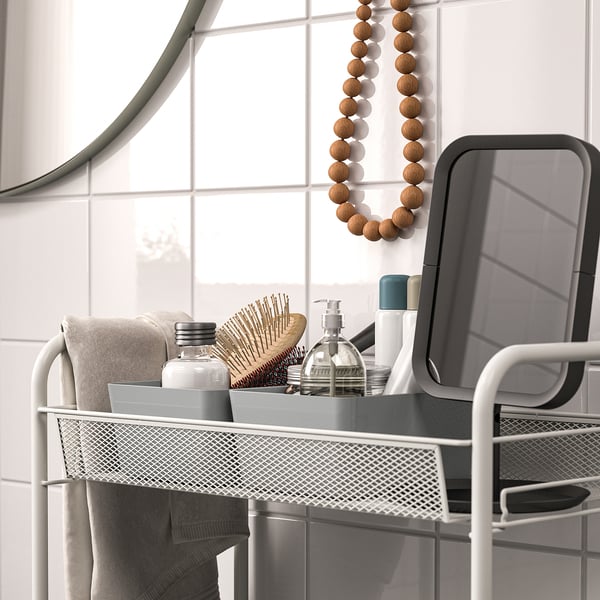 Support en métal avec savon et brosse à cheveux, miroir et carreaux.