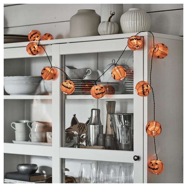 Guirlandes lumineuses citrouilles orange avec des visages de citrouille-lanterne, éclairant les espaces intérieurs et extérieurs.