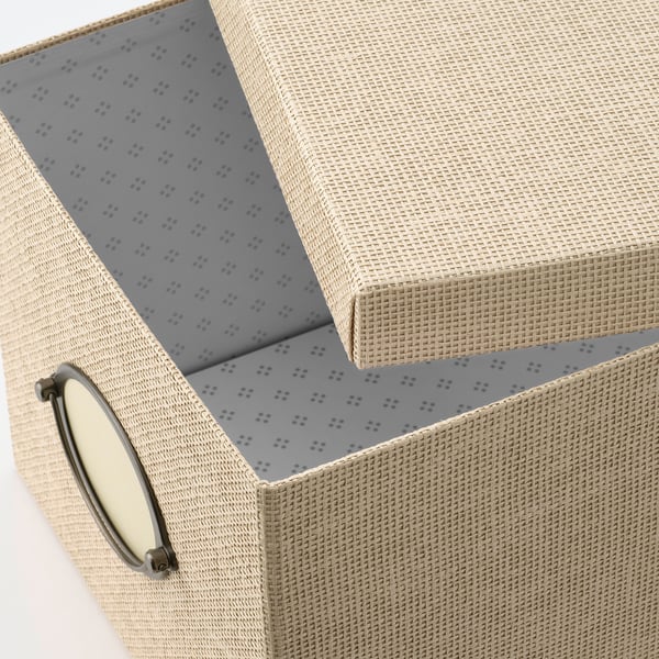 Une boîte de rangement en papier tissé avec poignée métallique, dotée d’un intérieur à pointillés classique.