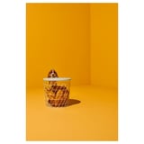 Panier blanc sur fond jaune ; un basset jette un coup d’œil par-dessus ; Design simple et aéré.