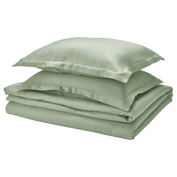 Nouvelle parure de lit verte 3 pièces : lyocell lisse et frais, soigneusement pliée avec des taies d’oreiller.