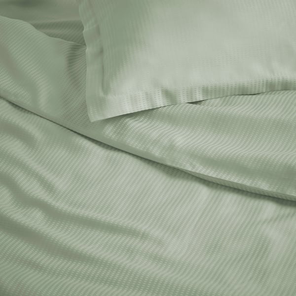 Parure de lit verte élégante avec motif subtil, tissu lyocell lisse et confortable.