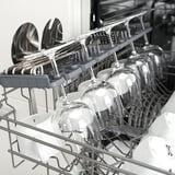 Noir et blanc un lave-vaisselle ouvert, montrant des verres et des couverts et illustrant un ustensile de cuisine conçu pour le nettoyage de la vaisselle.