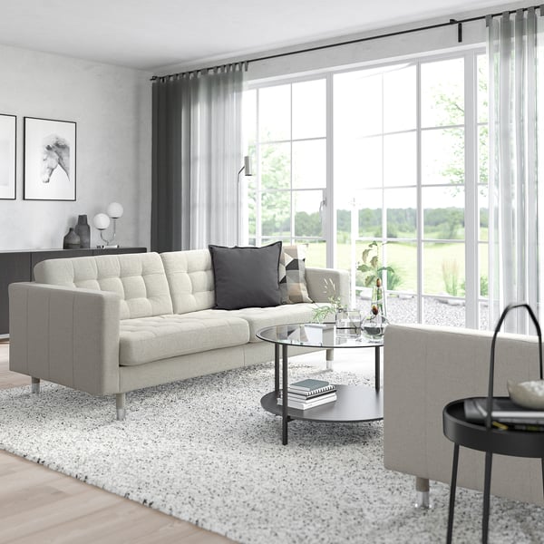 Salon moderne avec canapé LANDSKRONA, table basse et grandes fenêtres. Design élégant et minimaliste.