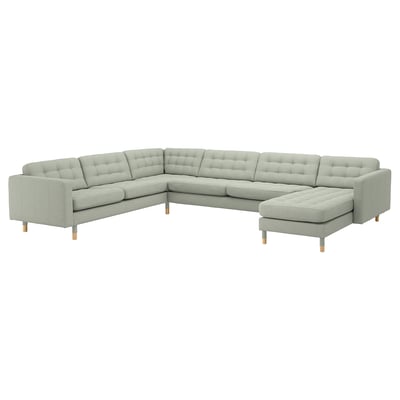 Canapé sectionnel moderne, gris clair, en forme de L avec dossier et coussins d’assise capitonnés, pieds en bois.